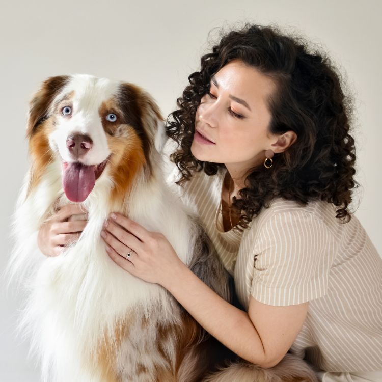 Woman petting Australian shepherd dog